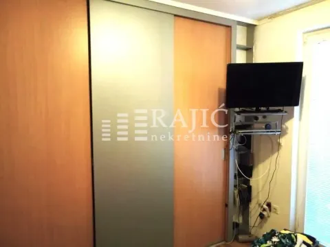 Living or bedroom with a large wardrobe and a wall-mounted TV. - image 8