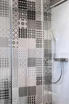 Moderan tuš sa dekorativnim pločicama i staklenom paravanom. - image 6
