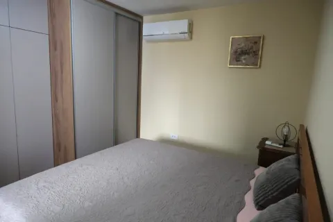 A simply furnished bedroom with a built-in wardrobe and air conditioning. - image 11