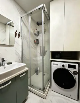 Moderno opremljeno kupatilo sa tuš kabinom, umivaonikom i mašinom za veš. - image 10