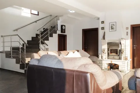 Living room with sofa set, fireplace, and staircase. - image 4