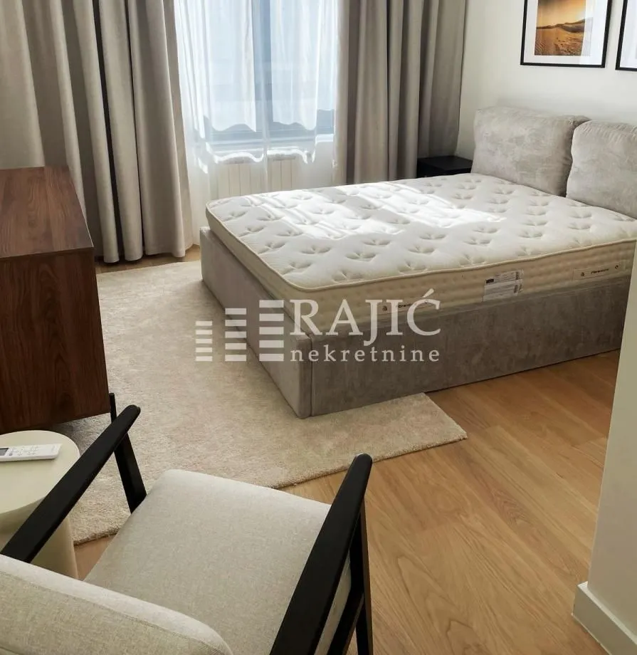 Bedroom with a double bed, armchair, and wardrobe.