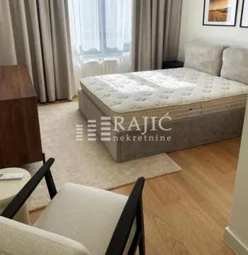Bedroom with a double bed, armchair, and wardrobe. - image 8