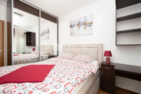 Furnished bedroom with a double bed, large mirrored wardrobe, and a bedside table. - image 8