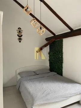Spavaća soba sa bračnim krevetom, drvenim gredama na plafonu i ukrasnim visilicama. - image 3
