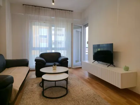 Svijetao dnevni boravak sa garniturom, televizorom i izlazom na terasu. - image 4