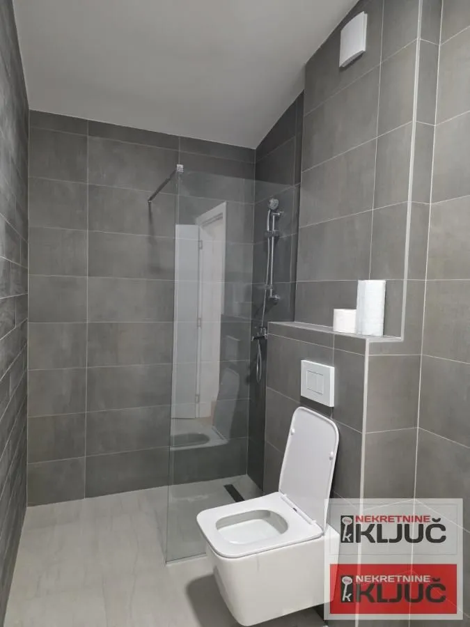 Moderno kupatilo sa tuš kabinom i wc šoljom.