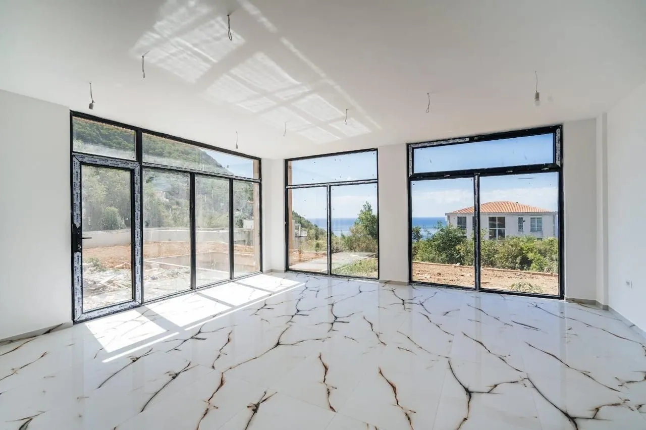 Empty bright room with large glass portals and a sea view.