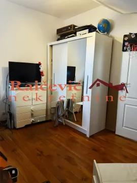 Bedroom with a white mirrored wardrobe and a chest of drawers with a television. - image 7