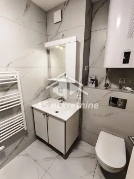 Modern bathroom equipped with a vanity, toilet, and marble-look tiles. - image 20