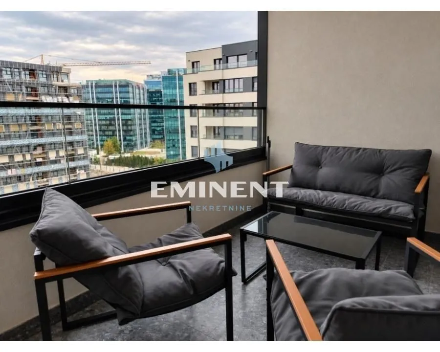Furnished balcony with seating set and city view.