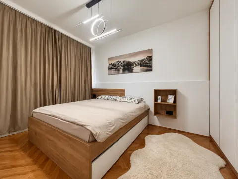 Modern bedroom with a double bed, wooden flooring, and a built-in wardrobe. - image 6
