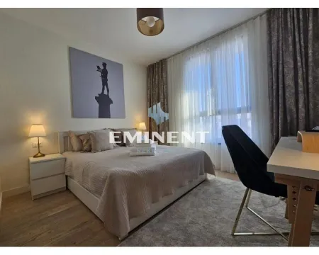 Furnished bedroom with a double bed, desk, and large window. - image 12