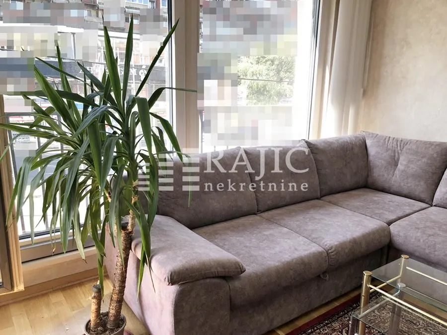 Comfortable living room with a corner sofa and a large window.