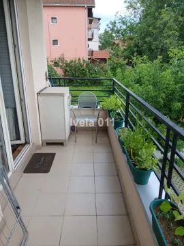 Manji popločani balkon sa ogradom i ukrasnim biljem u saksijama. - image 8