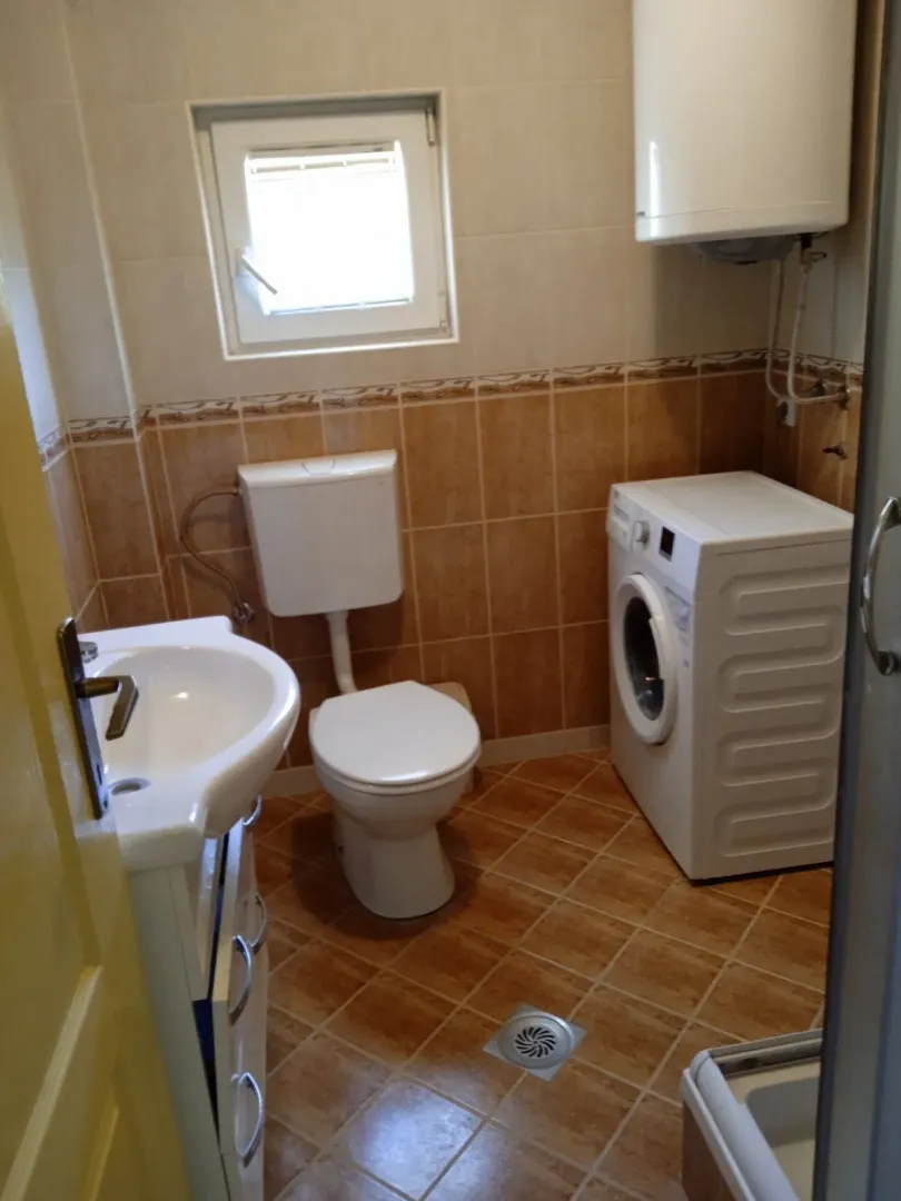 Smaller bathroom with sanitary fixtures, a shower cabin, and a washing machine.