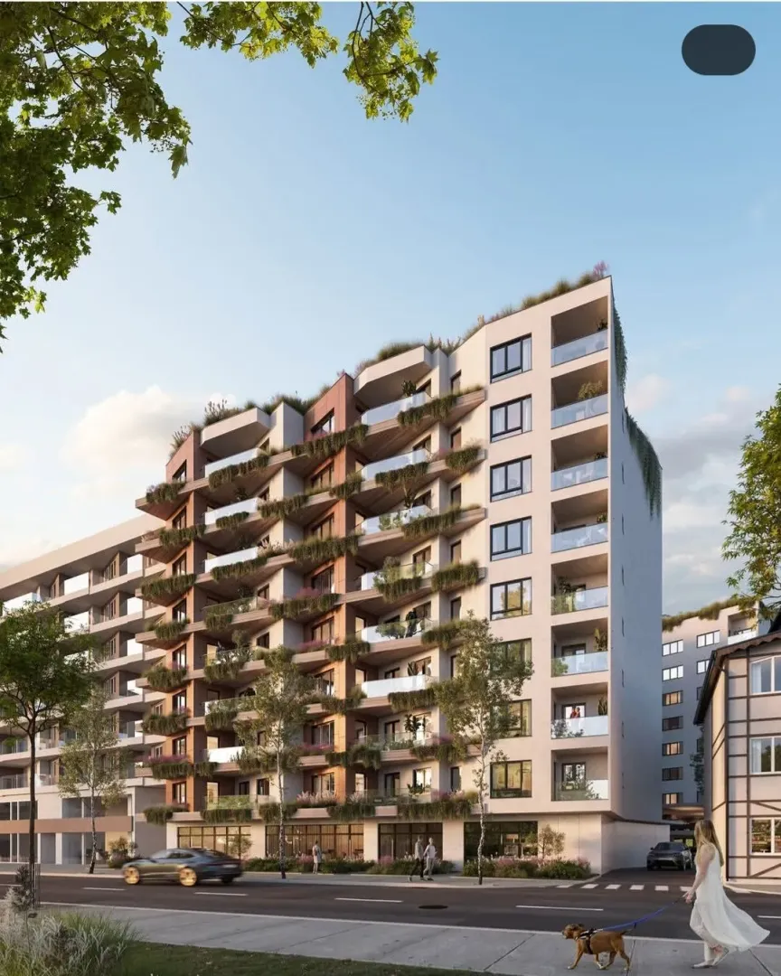 Exterior view of a modern multi-family residential building with terraces and greenery.