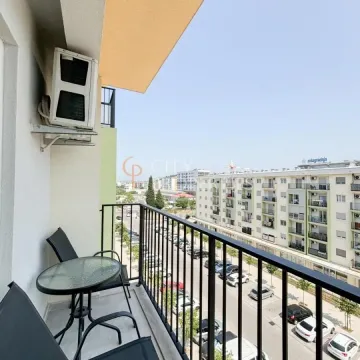 Small furnished balcony with a view of the street and buildings. - image 9