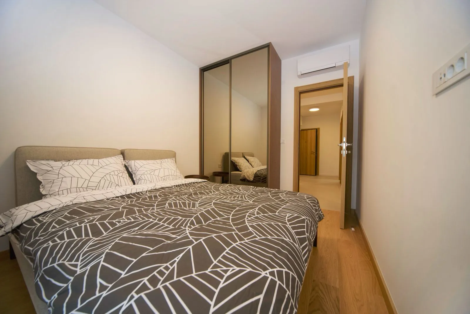 Bedroom with a double bed, mirrored wardrobe, and air conditioning.