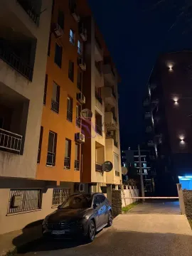 Noćni pogled na spoljašnjost zgrade sa parkingom i parkiranim automobilom. - image 9