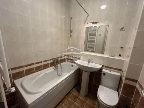 Bathroom equipped with a bathtub, washbasin, and toilet featuring ceramic tiles on the walls and floor. - image 17