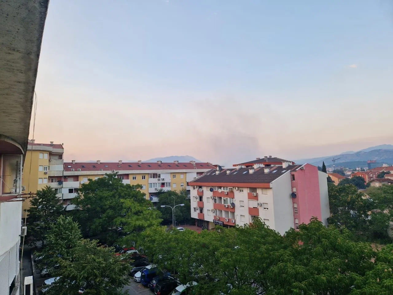 Pogled sa terase na okolne stambene zgrade i zelenilo.