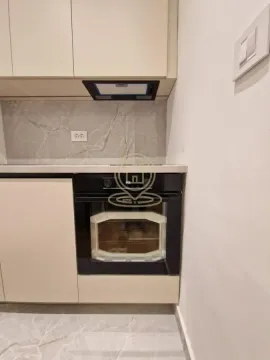 Dio kuhinje sa ugradnom rernom i elementima u bež boji. - image 24