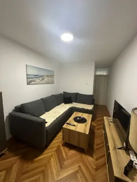 Living room with a sectional sofa, coffee table, and TV. - image 2