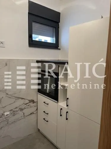 Small white kitchen with a built-in oven.