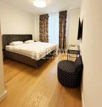 Furnished bedroom with a double bed, wooden flooring, and a window. - image 9