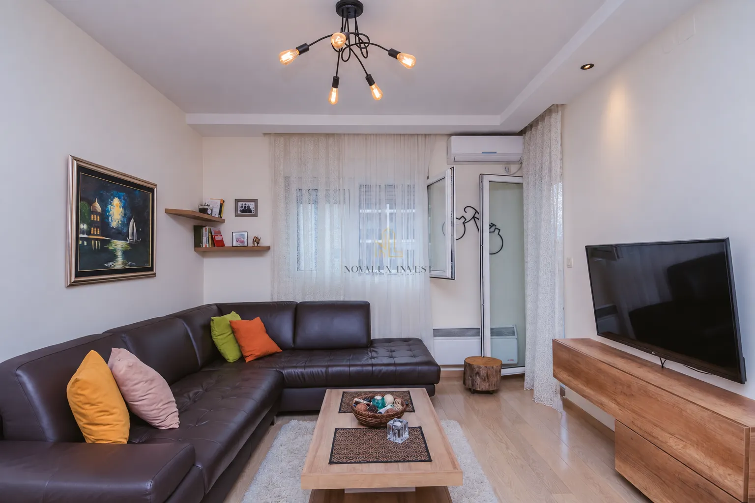 Living room with a sectional sofa, TV, and access to the terrace.
