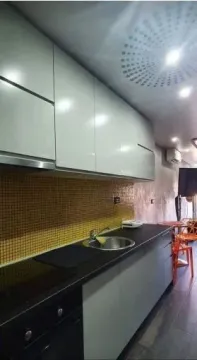Moderna kuhinja sa bijelim elementima i tamnom radnom površinom. - image 13