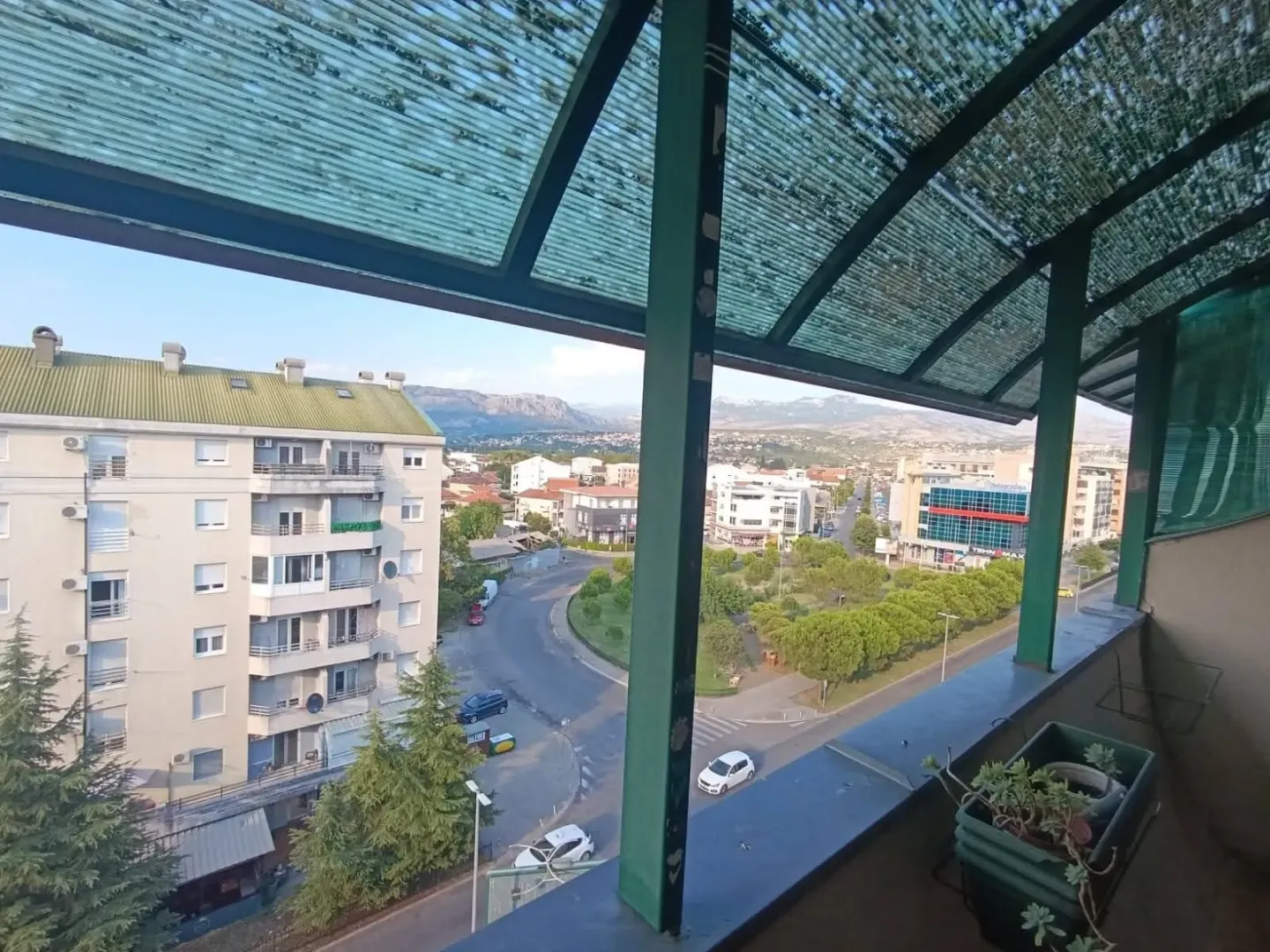 Pogled sa natkrivene terase na gradsku ulicu i okolne zgrade.