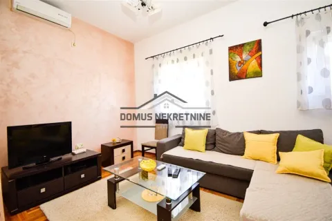 Living room with a sectional sofa, coffee table, and TV. - image 2