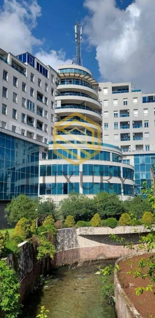 Spoljašnji izgled moderne stambene zgrade sa terasama i uređenim okruženjem.