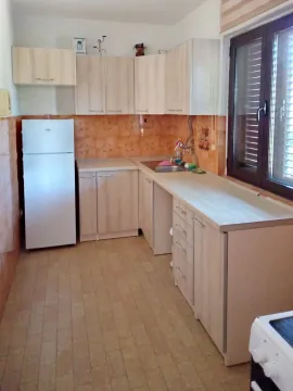 Small kitchen with light wood cabinets and a white refrigerator. - image 11