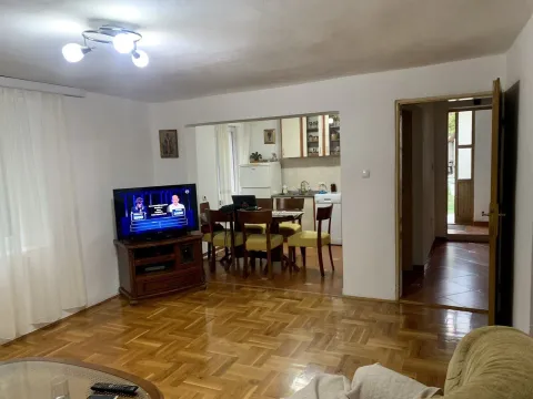 A bright living room with parquet flooring, a dining area, and a kitchen in the background. - image 9