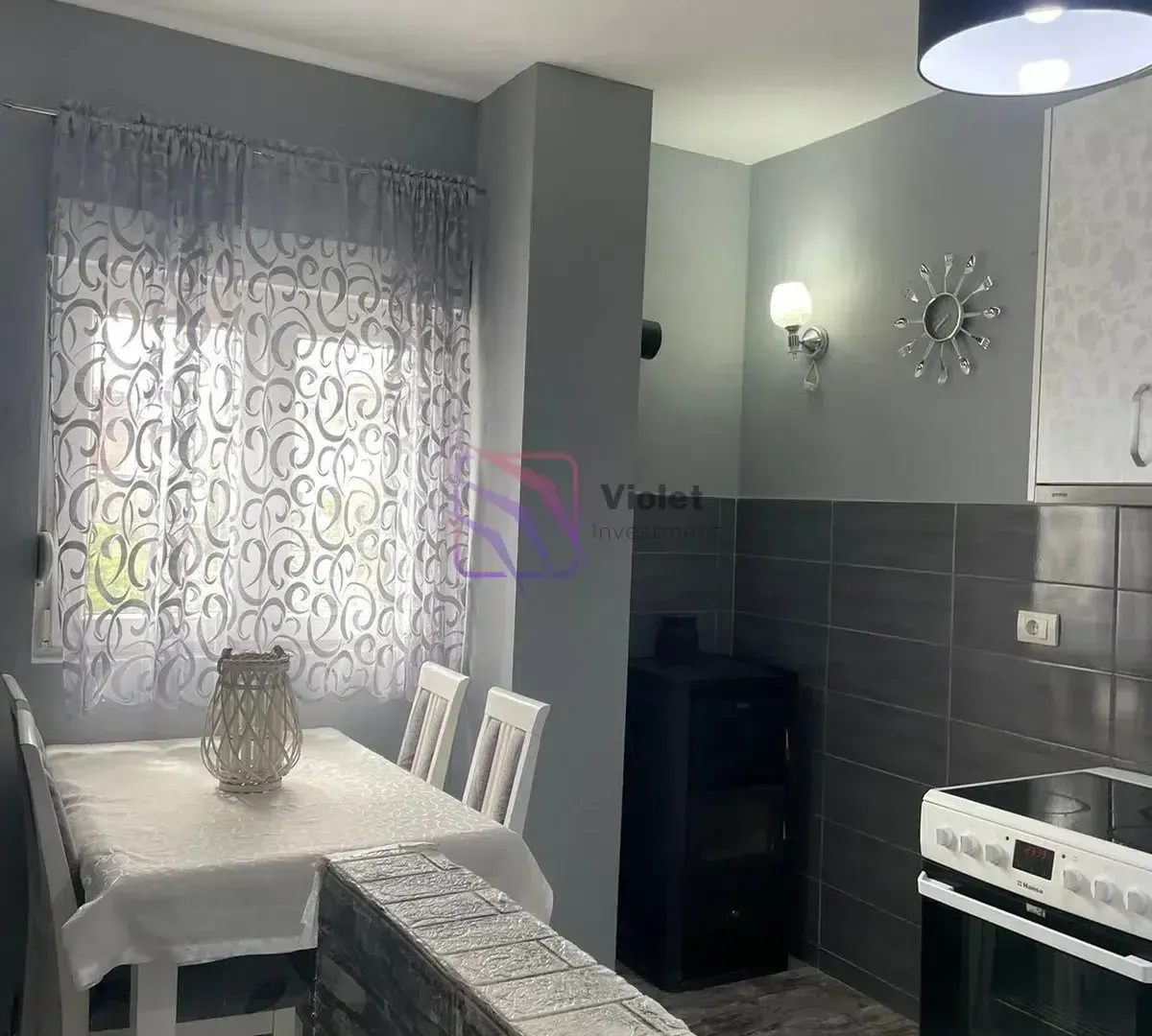 Kitchen with dining area and grey walls.