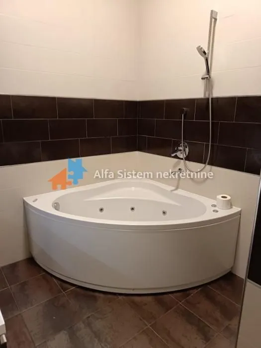 Bathroom equipped with a corner whirlpool bathtub and shower faucet.