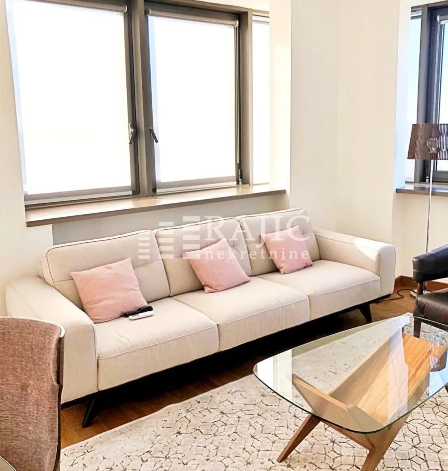 Living room with light sofa and large windows.