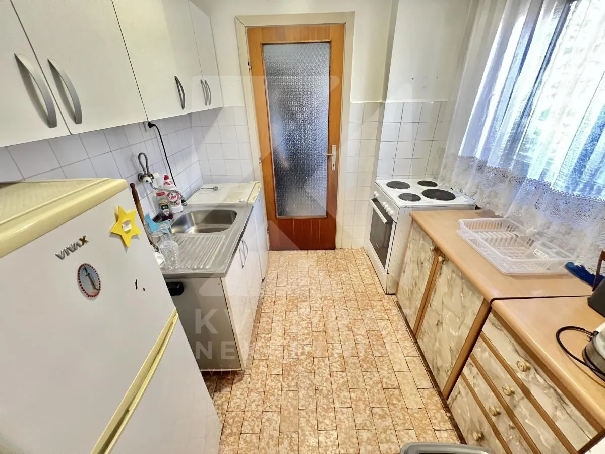 Compact kitchen with a sink, stove, and kitchen cabinets.