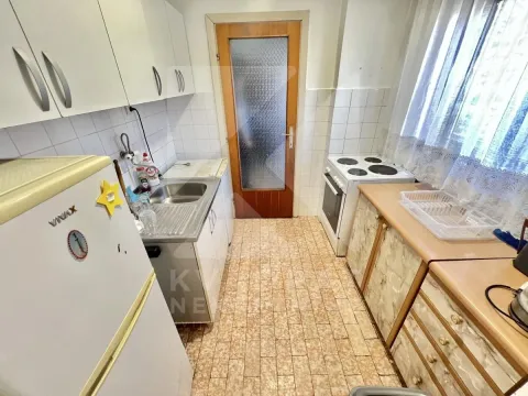 Compact kitchen with a sink, stove, and kitchen cabinets. - image 7