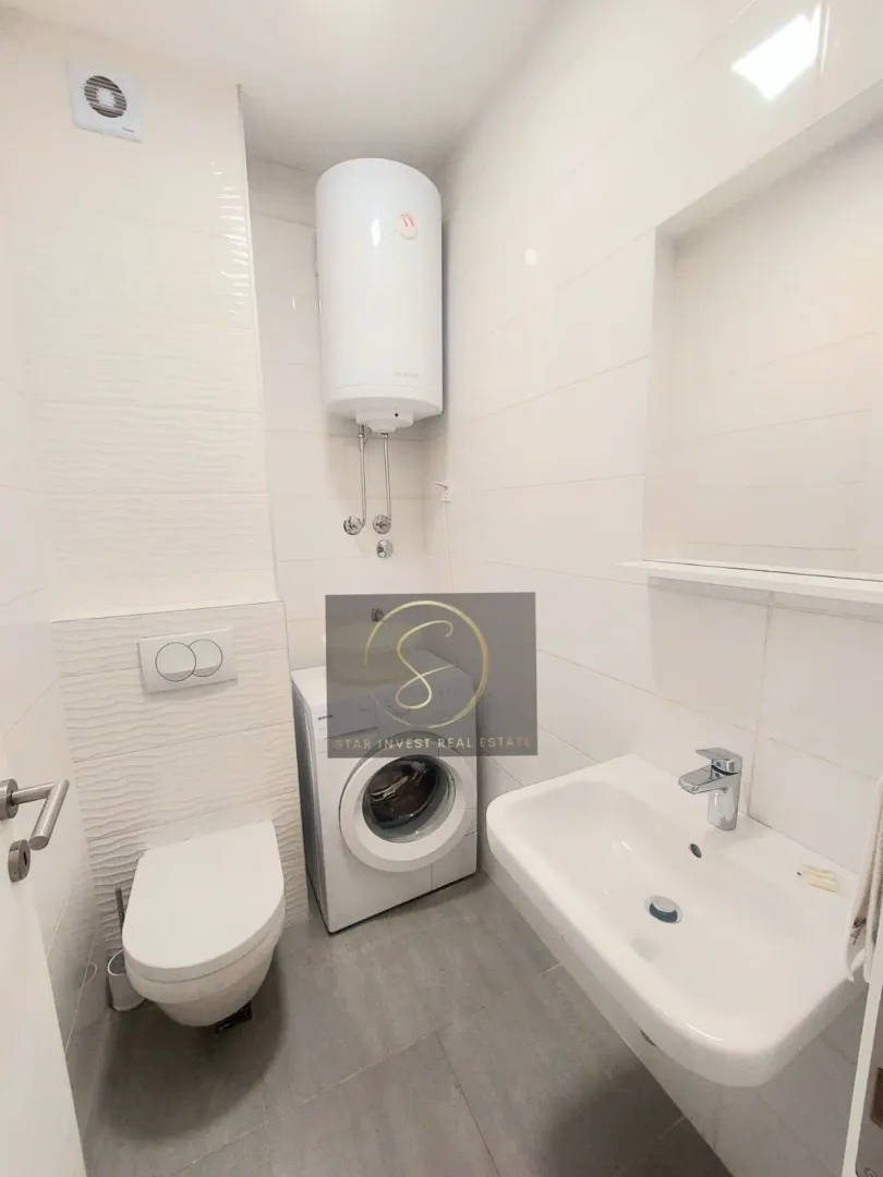 Modernly equipped bathroom with sanitary ware and a washing machine.