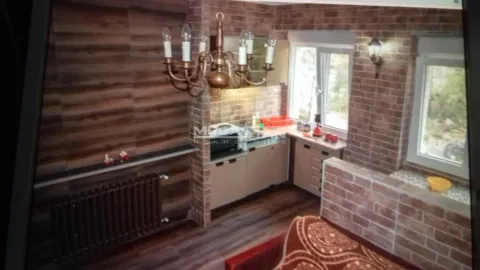 Kitchen with wooden elements, brick wall, and a radiator. - image 5