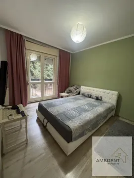 Spavaća soba sa bračnim krevetom, balkonskim vratima i zelenim zidom. - image 9