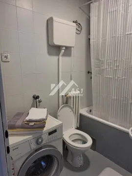 Small bathroom with bathtub, toilet, and washing machine. - image 4