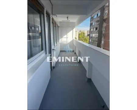 Dugi zatvoreni balkon sa velikim prozorima i pogledom na grad. - image 15