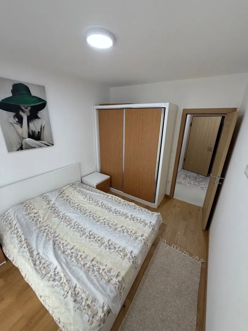 Furnished bedroom with a double bed, wardrobe, and wall art.