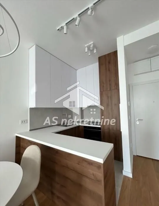 Modern U-shaped kitchen with white cabinetry and wooden details.
