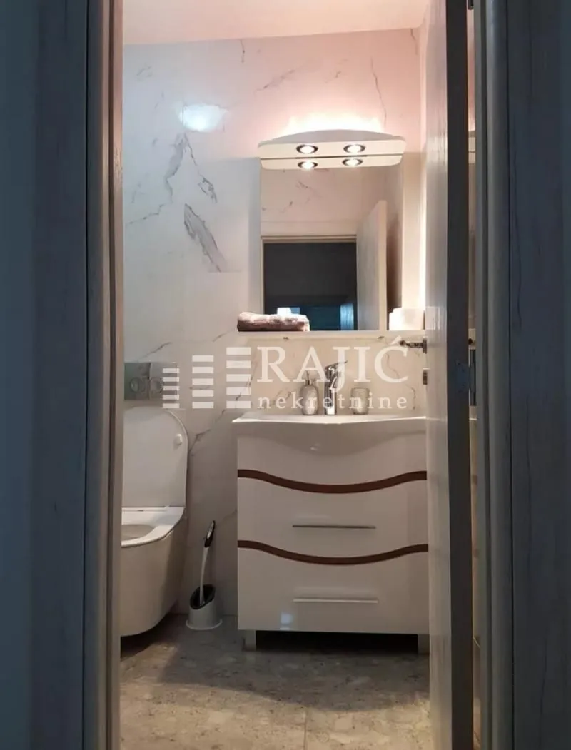 View of a modernly equipped bathroom with a vanity and toilet.